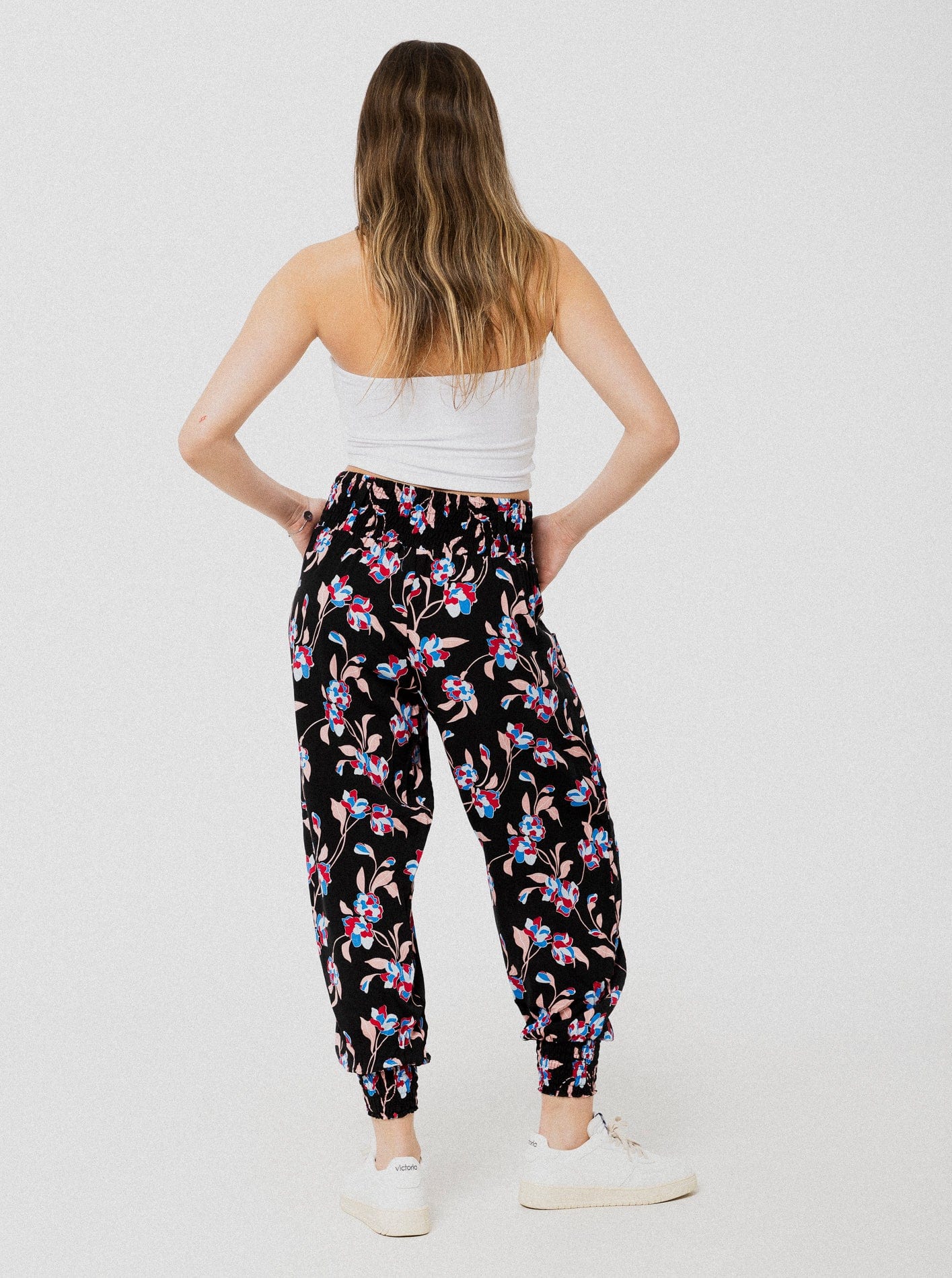 Pantalon noir à motif de fleurs bleu et rouge ample et confortable avec élastique aux chevilles et à la taille.