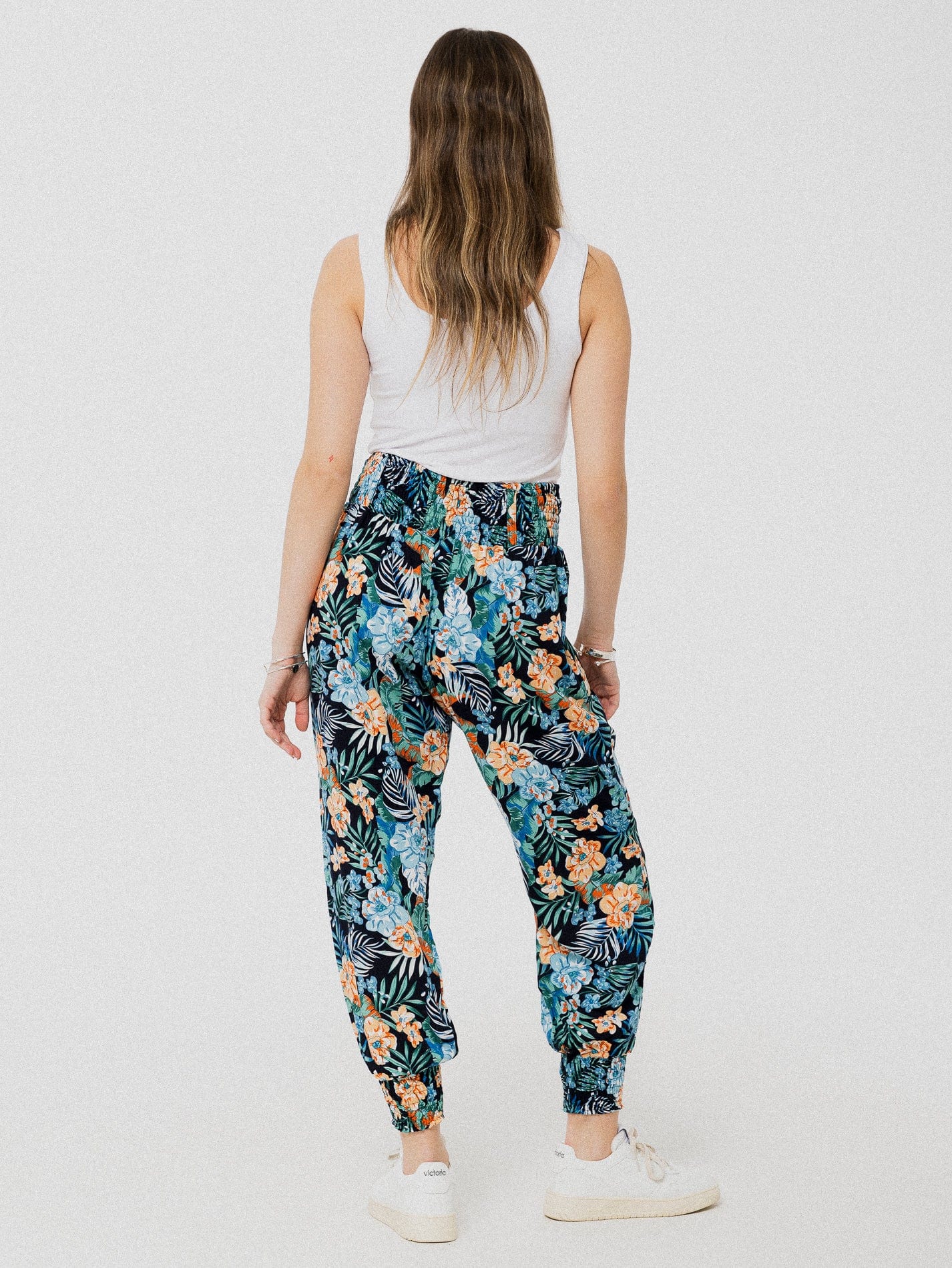 Pantalon noir à motif de fleurs tropicales marine et beige ample et confortable avec élastique aux chevilles et à la taille.