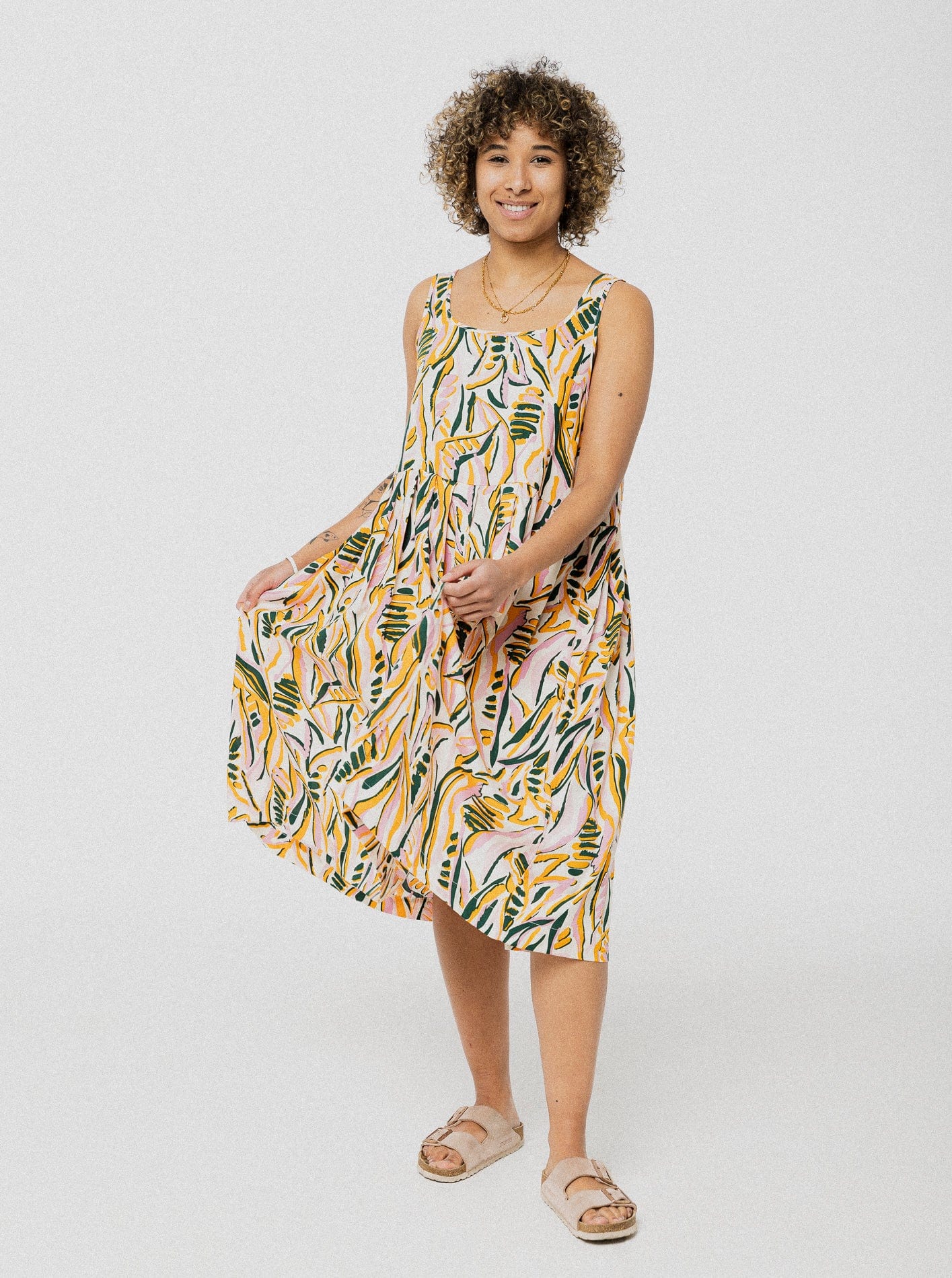 Robe longue ample et confortable crème avec motif de feuilles jaune et vert avec des bretelles ajustables.