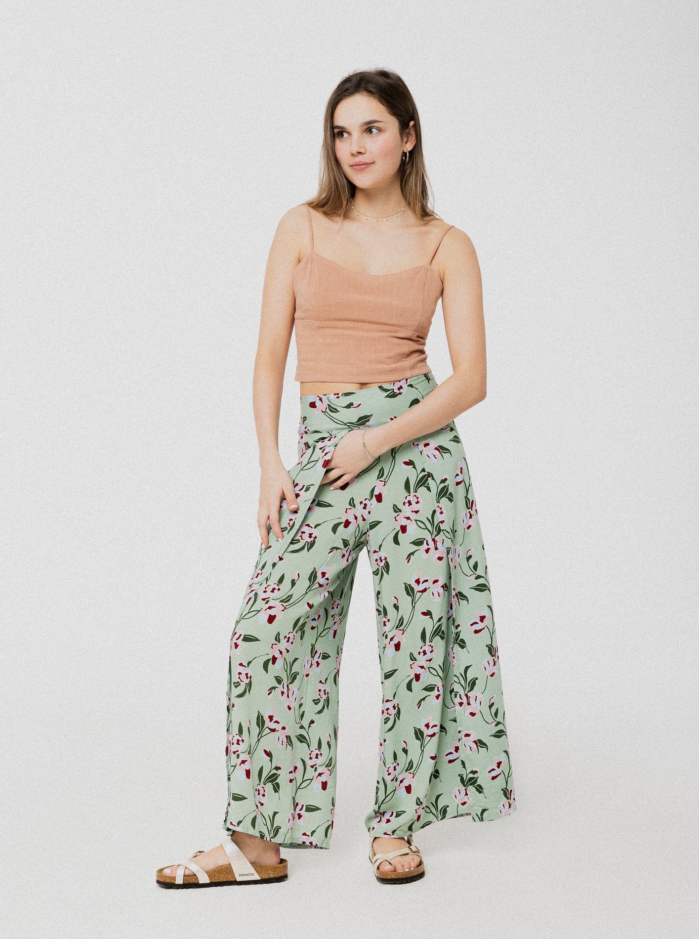 Pantalon ample et confortable vert à motif de fleur rose avec une subtile ouverture à l'avant et élastique dans le dos.