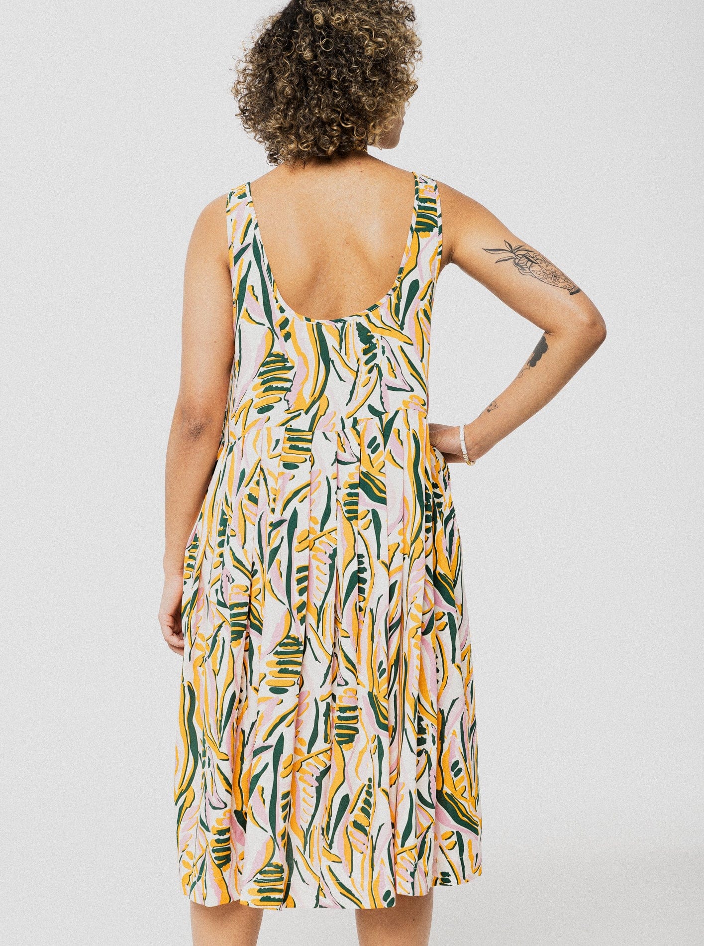 Robe longue ample et confortable crème avec motif de feuilles jaune et vert avec des bretelles ajustables.