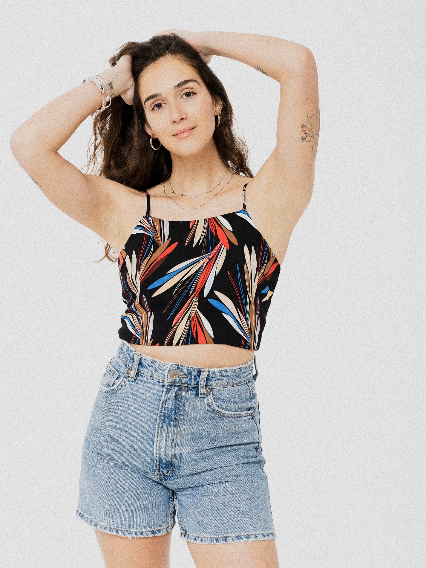 Crop top noire avec motif de feuilles bleu, beige, rouge et beige  très léger attachée dans le dos avec une boucle.