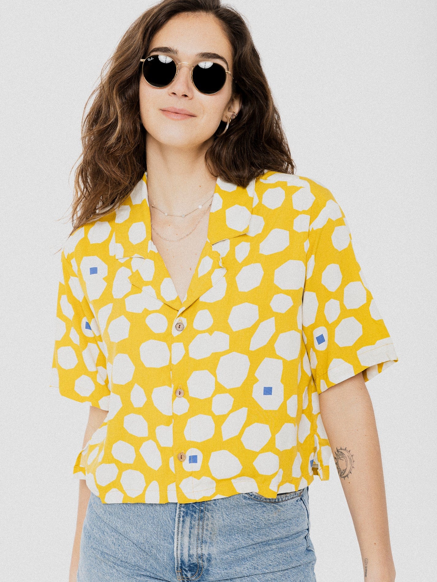 Blouse ample et confortable à manche courte jaune avec motif de ronds asymétriques blanc et quelques petits carrés bleu.