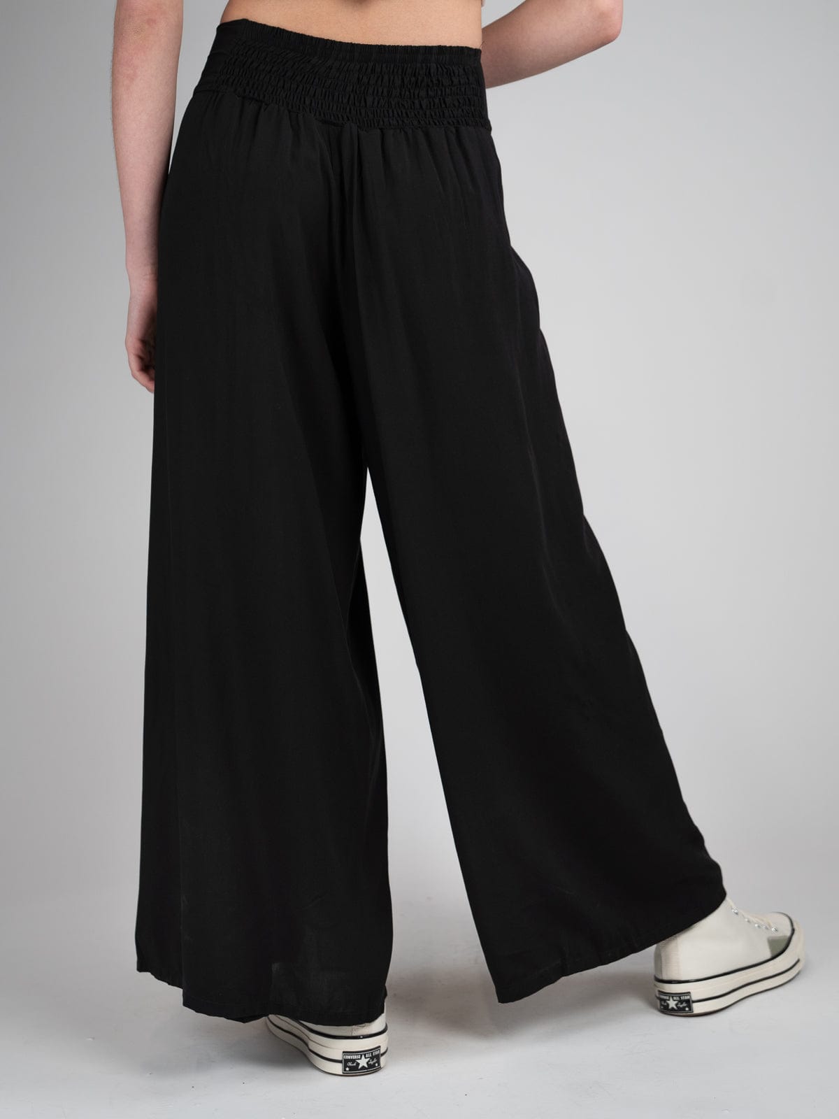 Pantalon ample et confortable noir avec une subtile ouverture à l'avant et élastique dans le dos.